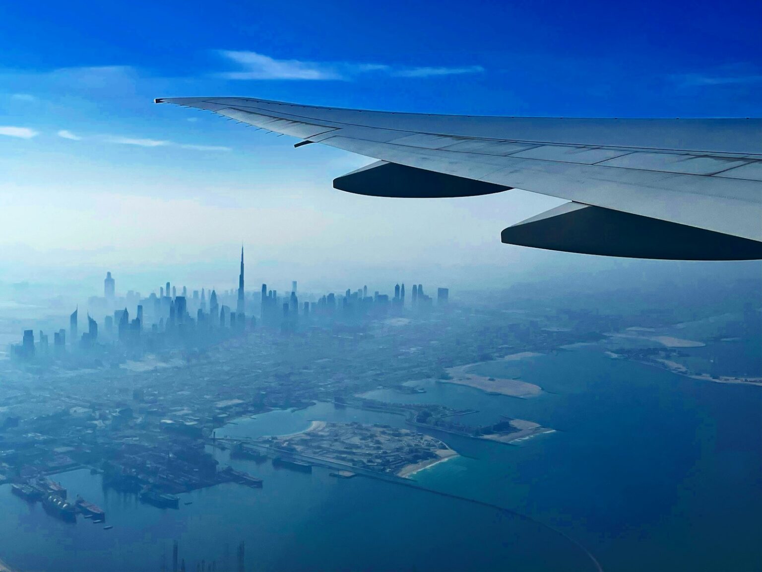 the wing of an airplane flying over a city